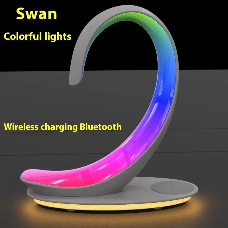 White swan wireless charging Bluetooth speaker with colourful ambient lighting on desktop