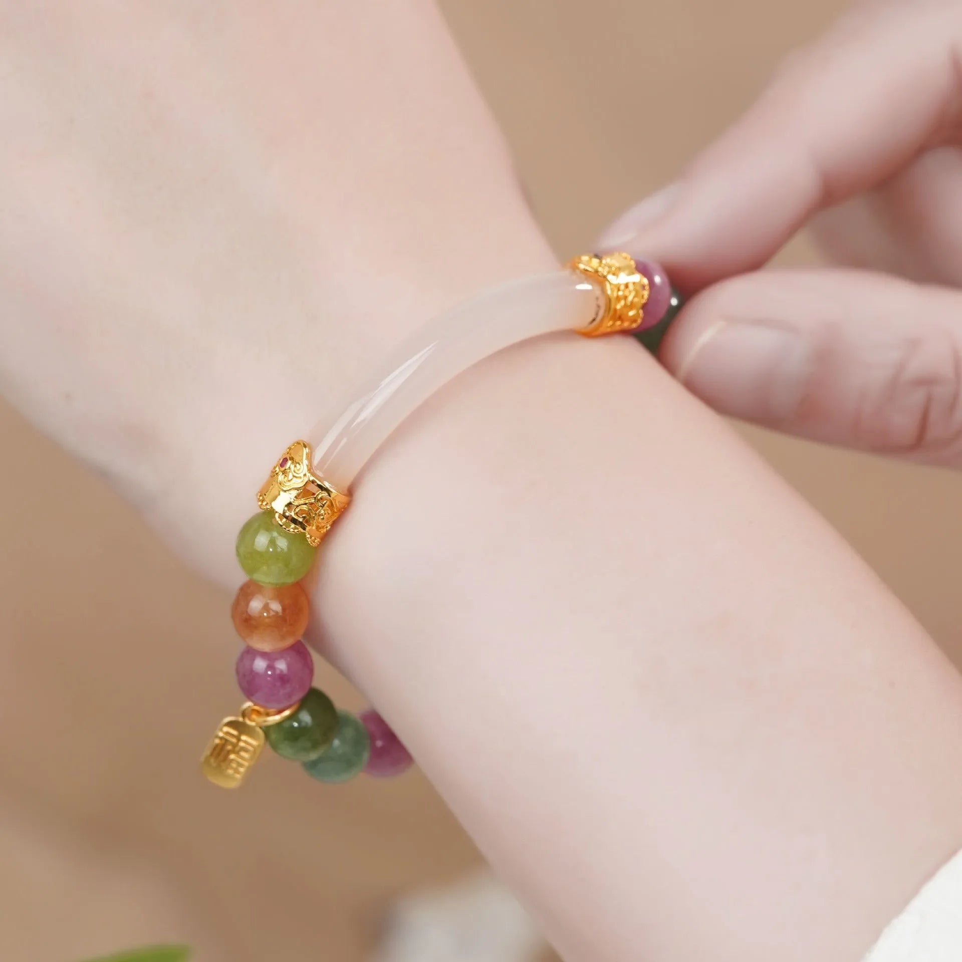 Rainbow-coloured women's half bracelet made from natural tourmaline with a pith centrepiece.