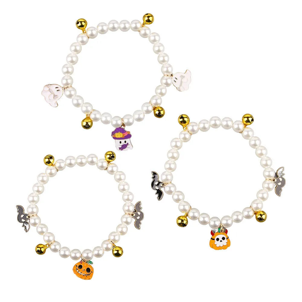 Close-up of a simulated pearl cat collar with a detailed Halloween pumpkin charm, showing the purple ghost design variant.