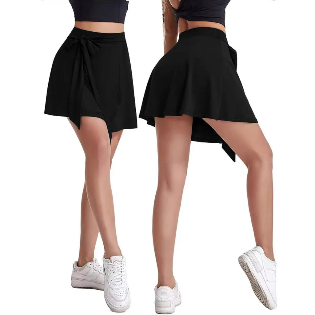 Black thigh-length unisex sports skirt with high waist and built-in shorts, laid flat.
