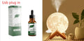 White spherical lunar humidifier night light with USB charging cable on a wooden surface.