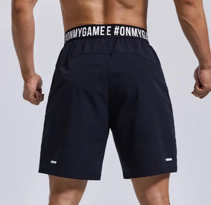 Men's loose fit cropped shorts in black with elastic fly opening and letter detailing