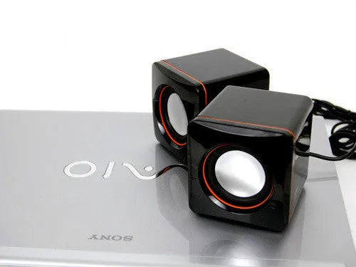 Small black square USB-powered computer speaker for desktop audio enhancement