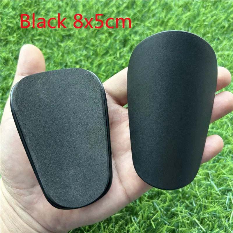 Extra small mini football shin guards in black and white colours measuring 8x5cm