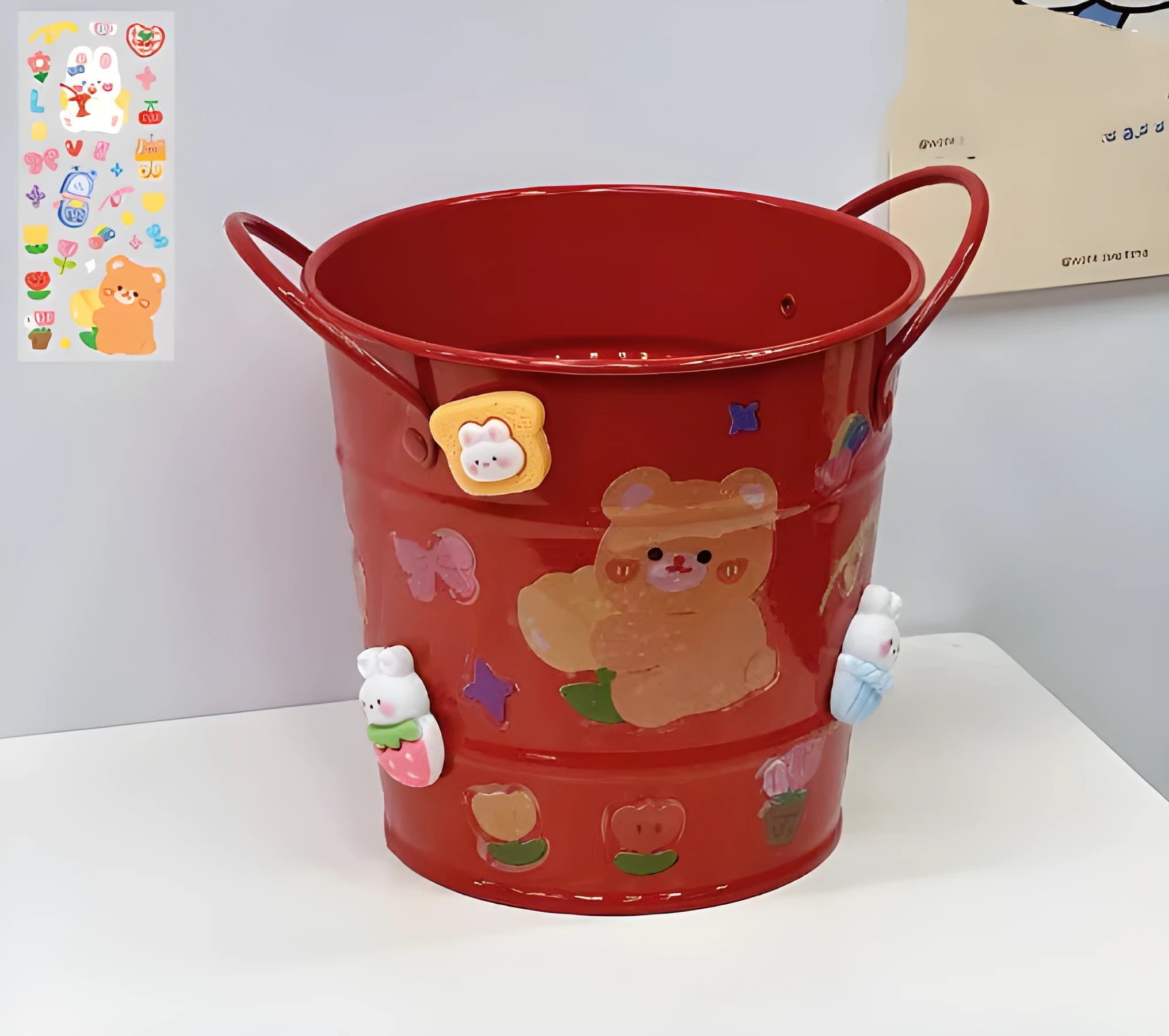 Round metal Creative Iron Art pen holder shown in pink, green, red, white, and yellow colour options on a desk.