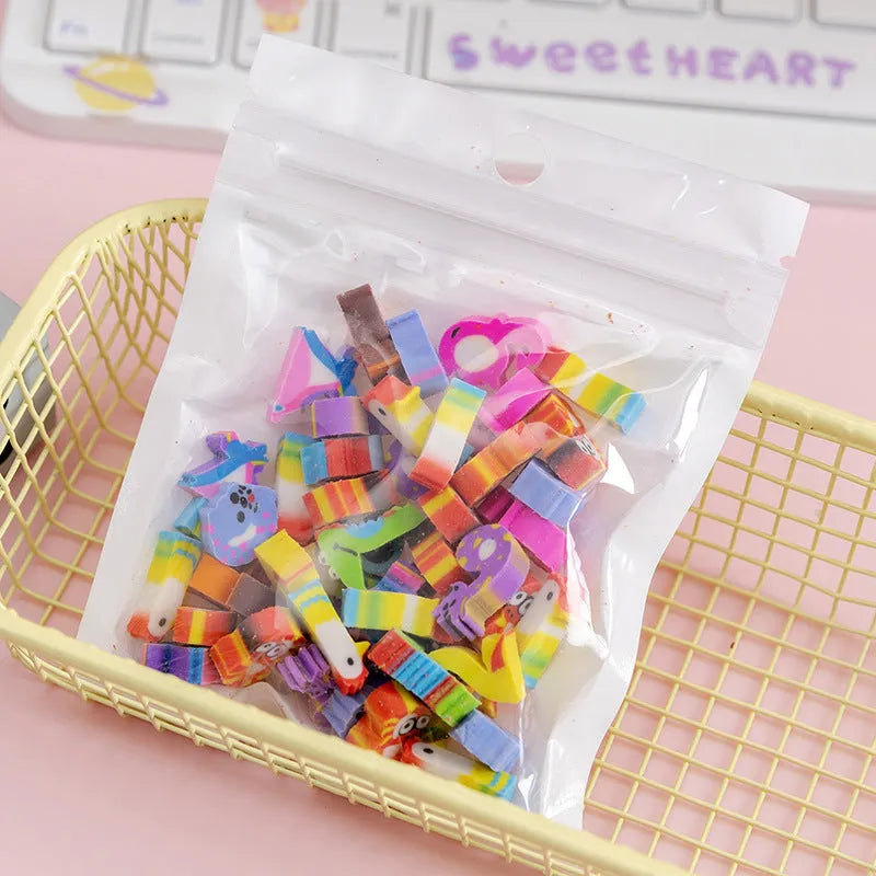 50 colourful cartoon mini erasers in shapes of fruits, animals, and cakes, displayed next to a pearlescent film bag.