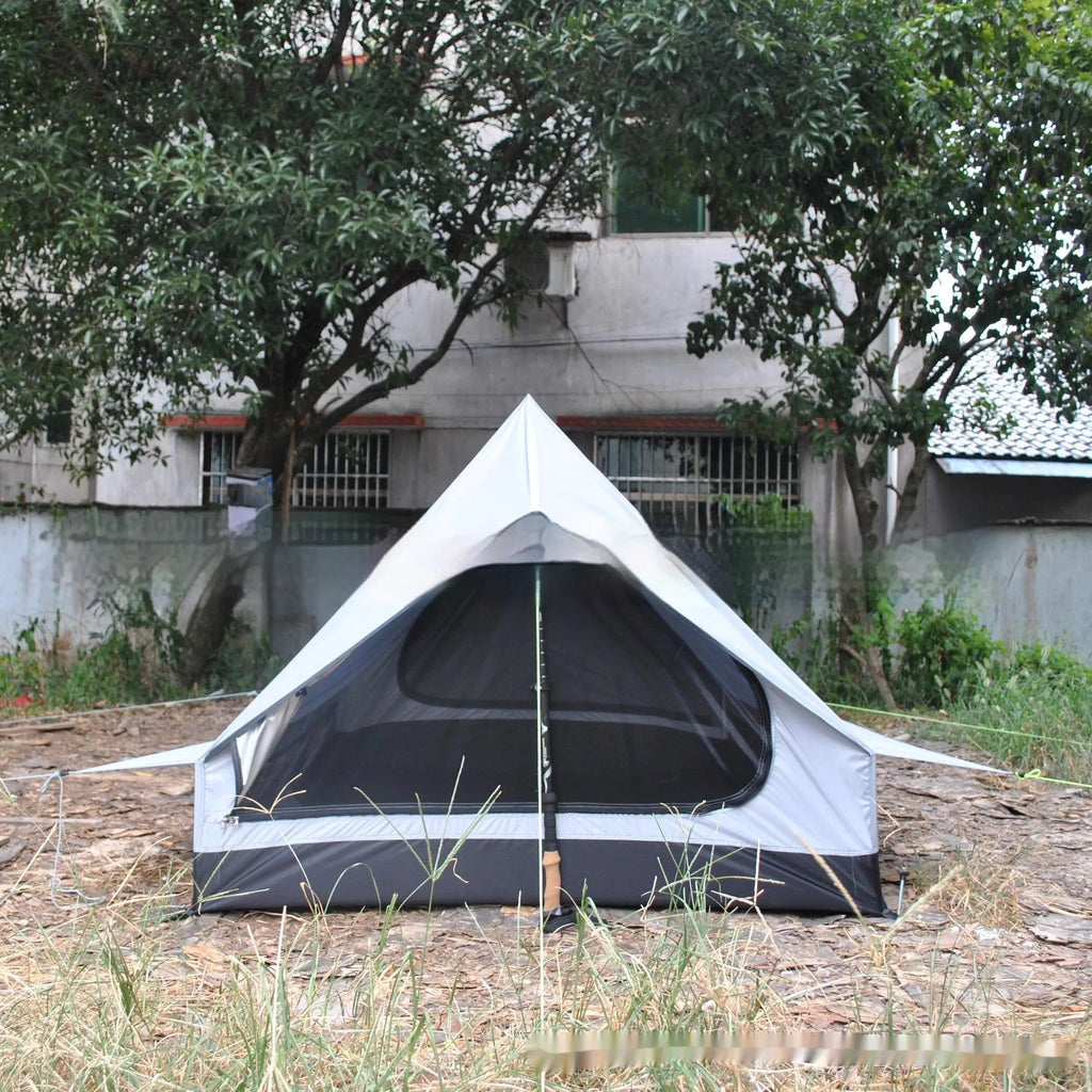 Brown A-line cabin tent pitched with hiking poles as structural support showing spacious interior for 2-3 people