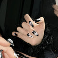 Black and pink heart hand-painted detachable artificial nails with bow design, shown in sizes XS, S, M, L.