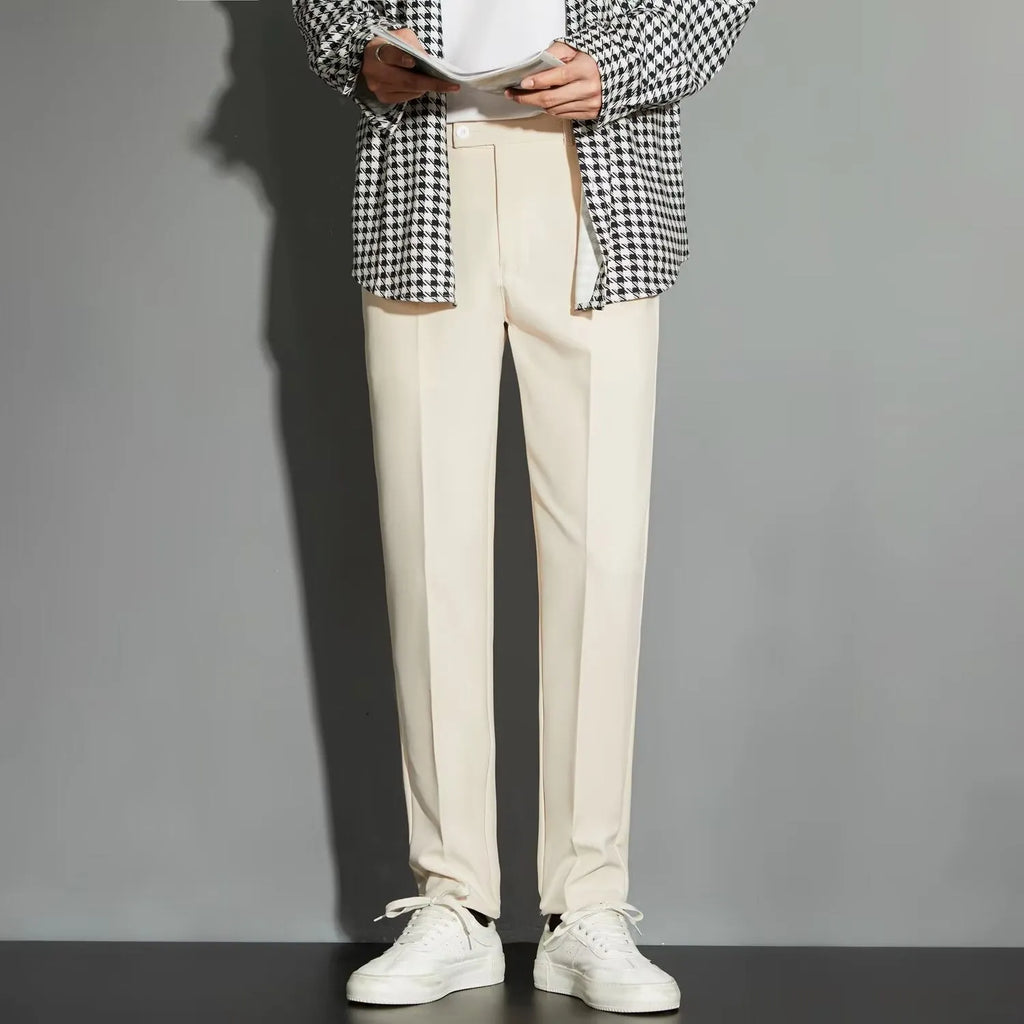Man wearing straight-leg suit trousers with an ankle-length draping effect in a light colour.