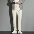 Man wearing straight-leg suit trousers with an ankle-length draping effect in a light colour.