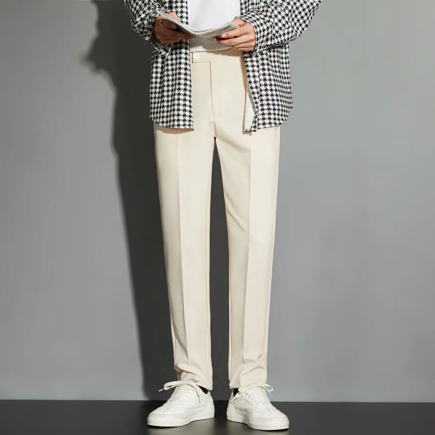 Man wearing straight-leg suit trousers with an ankle-length draping effect in a light colour.