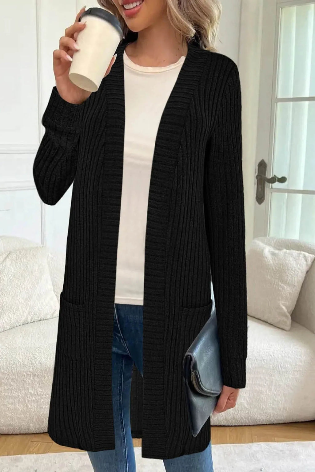 Long sleeve loose fit knitted cardigan jacket in black, shown with two front pockets.