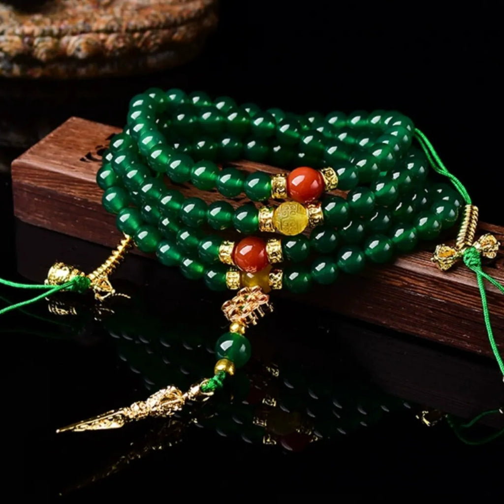 Natural green agate multi-strand bracelet with sliding knot closure on a wrist.