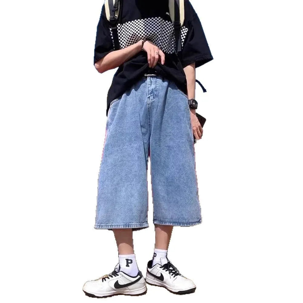 Man wearing blue washed denim high waist pirate shorts with a cropped, straight leg