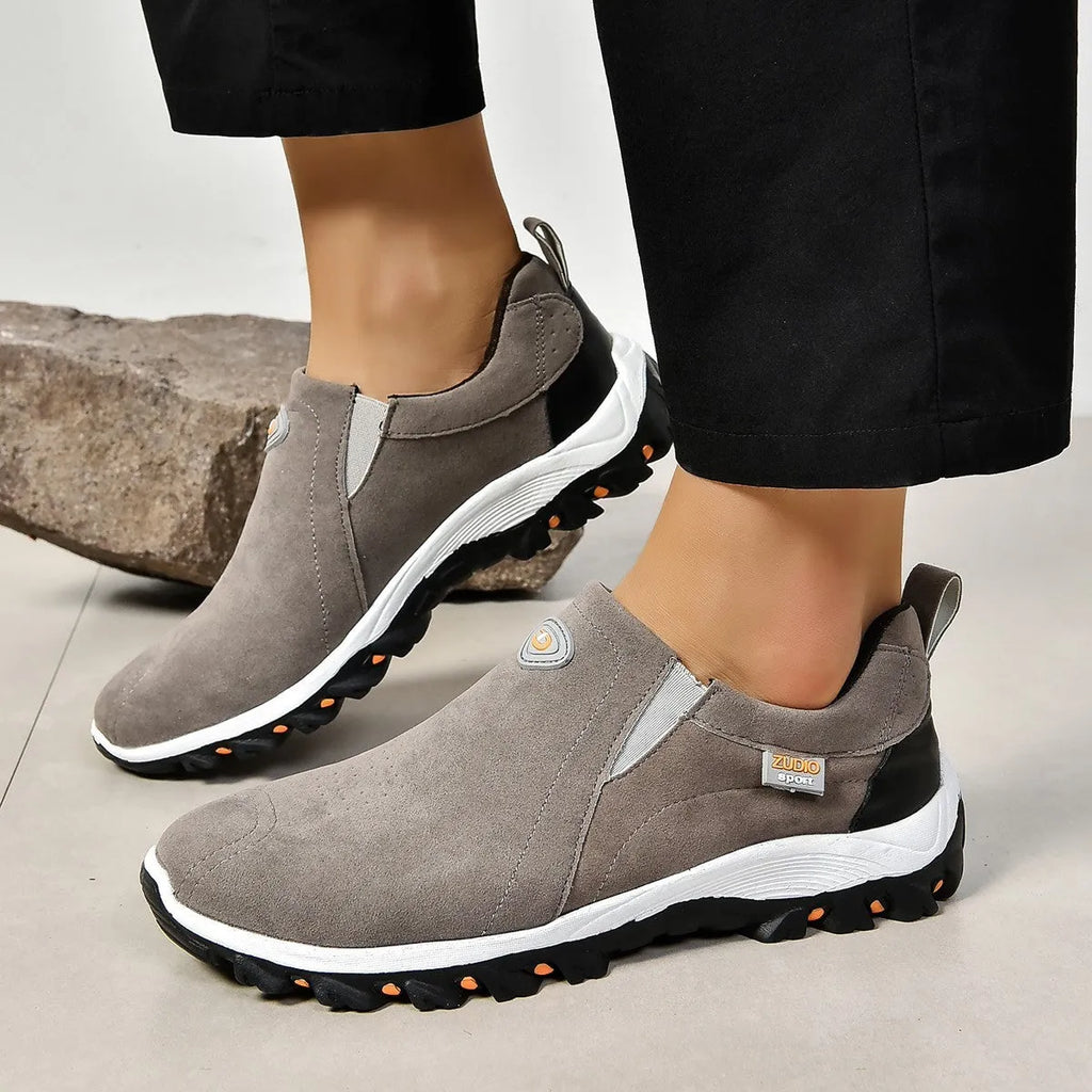 Men's grey slip-on shoe cover with round toe and rubber sole on a white background.