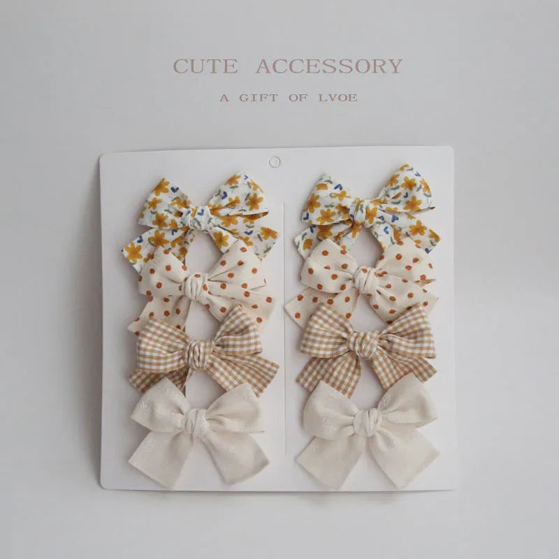 Children's fabric bow hairclips set showing dovetail design in multiple colour options