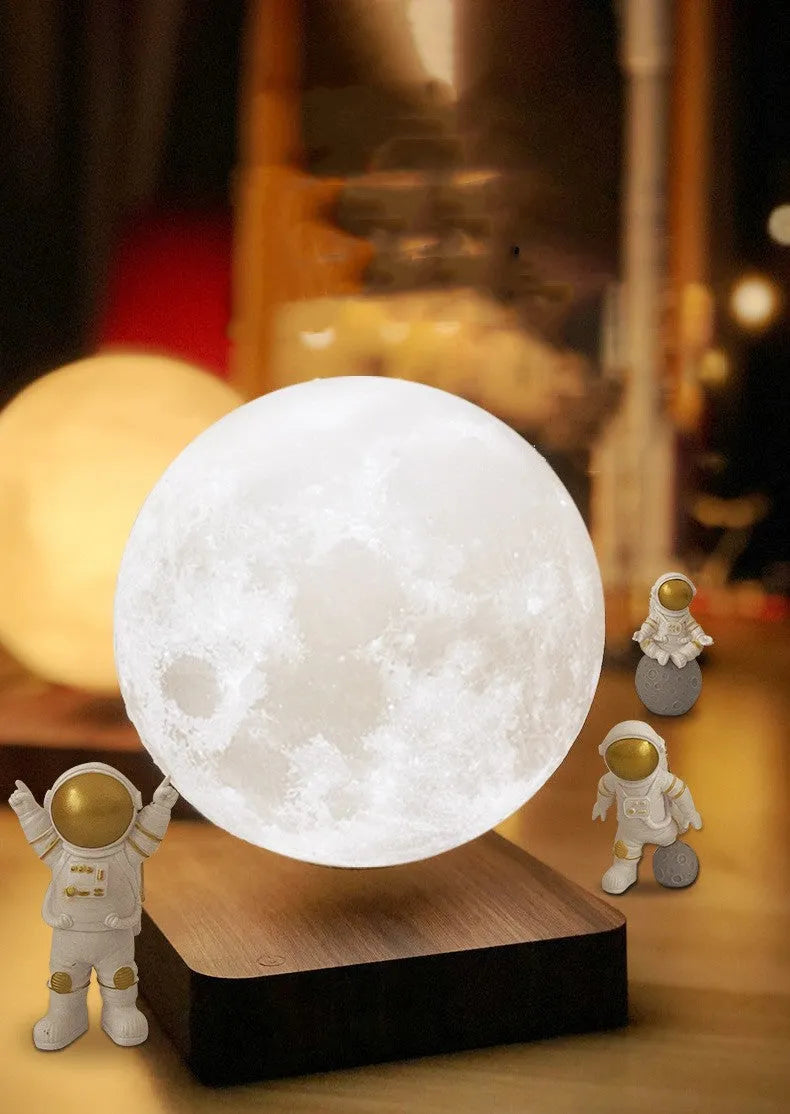 Maglev floating moon and earth night light with LED glow and small astronaut figurines on a table.