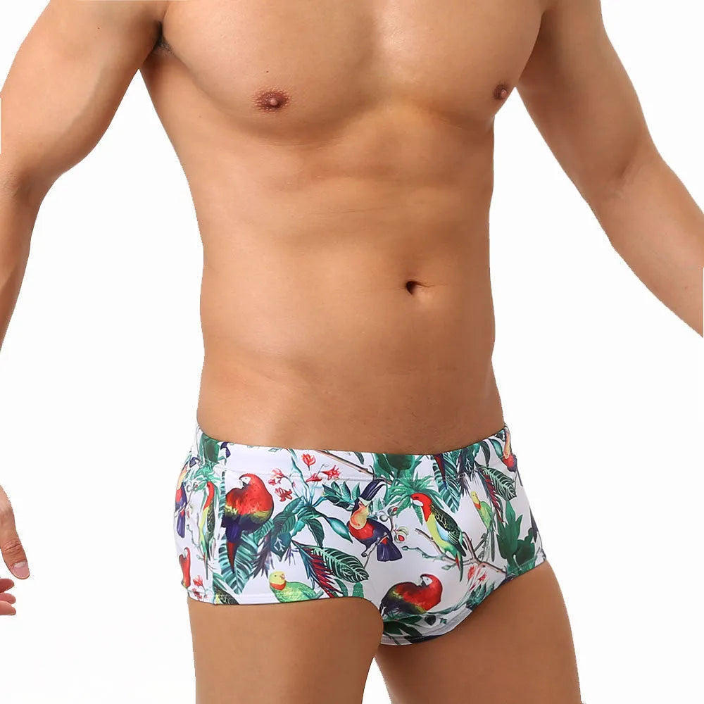 Men's floral and bird print nylon swimming trunks in boxer brief style with cup cover.