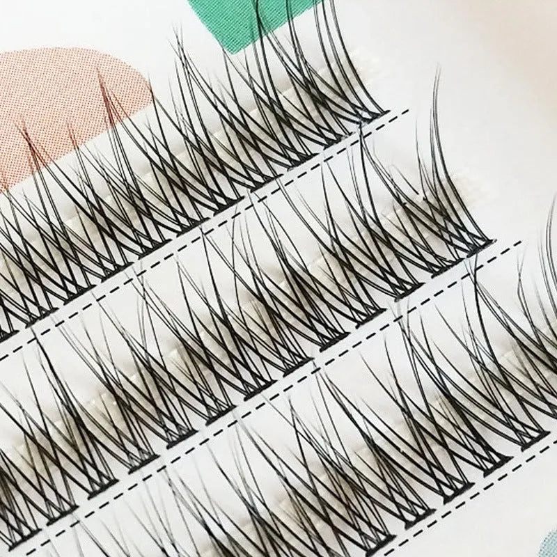 Black V-shaped fairy fishtail false eyelashes with thick segments on a clear background.