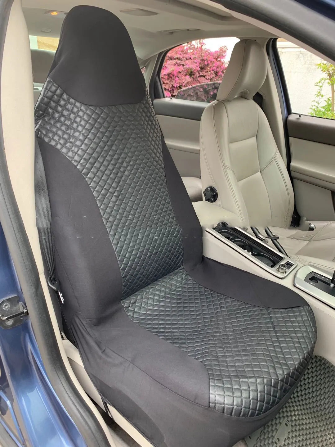 Black quilted automotive seat cover made from PU and polyester fabric, shown with plastic attachment hooks.