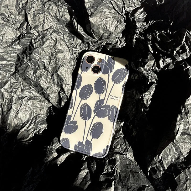 Black silicone iPhone case with a white tulip pattern design on the back.
