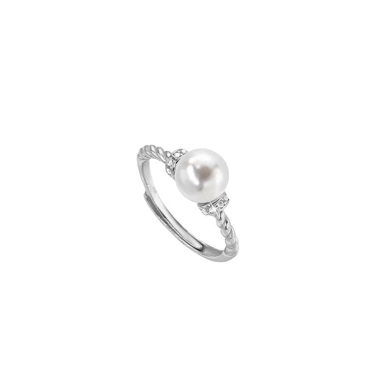 Adjustable antique twist ring with a pearl inlay, shown in gold and silver copper finish.
