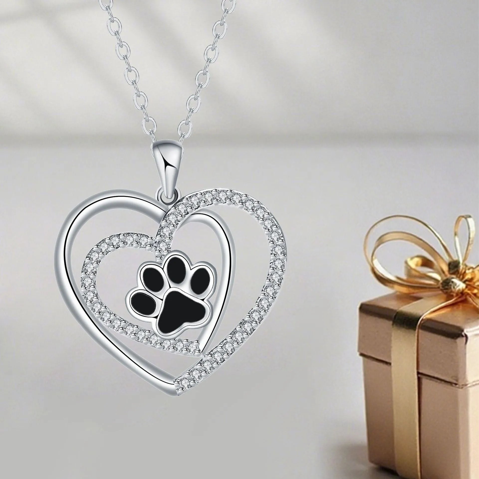 Women's necklace with a heart-shaped dog paw print copper pendant on a cross chain.
