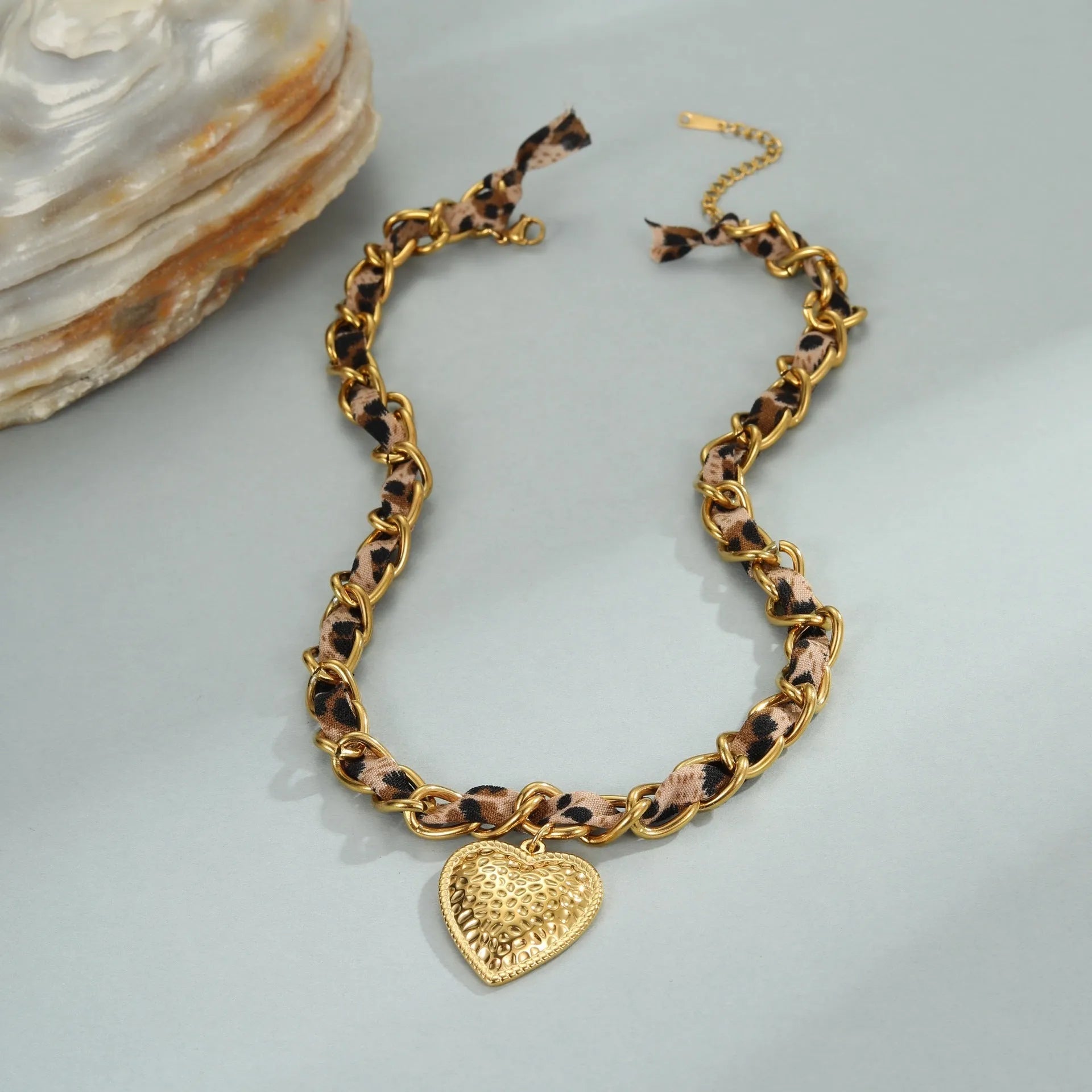 Gold-plated stainless steel necklace with leopard and love geometric pendant on an adjustable chain.