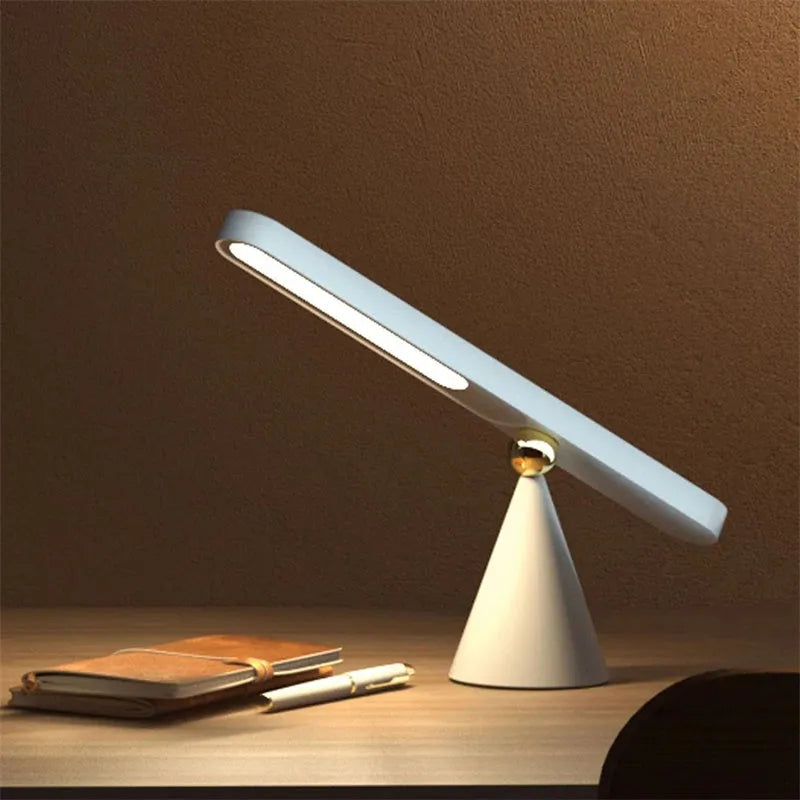 Geometric desk lamp with magnetic base shown attached to metal surface as wall light