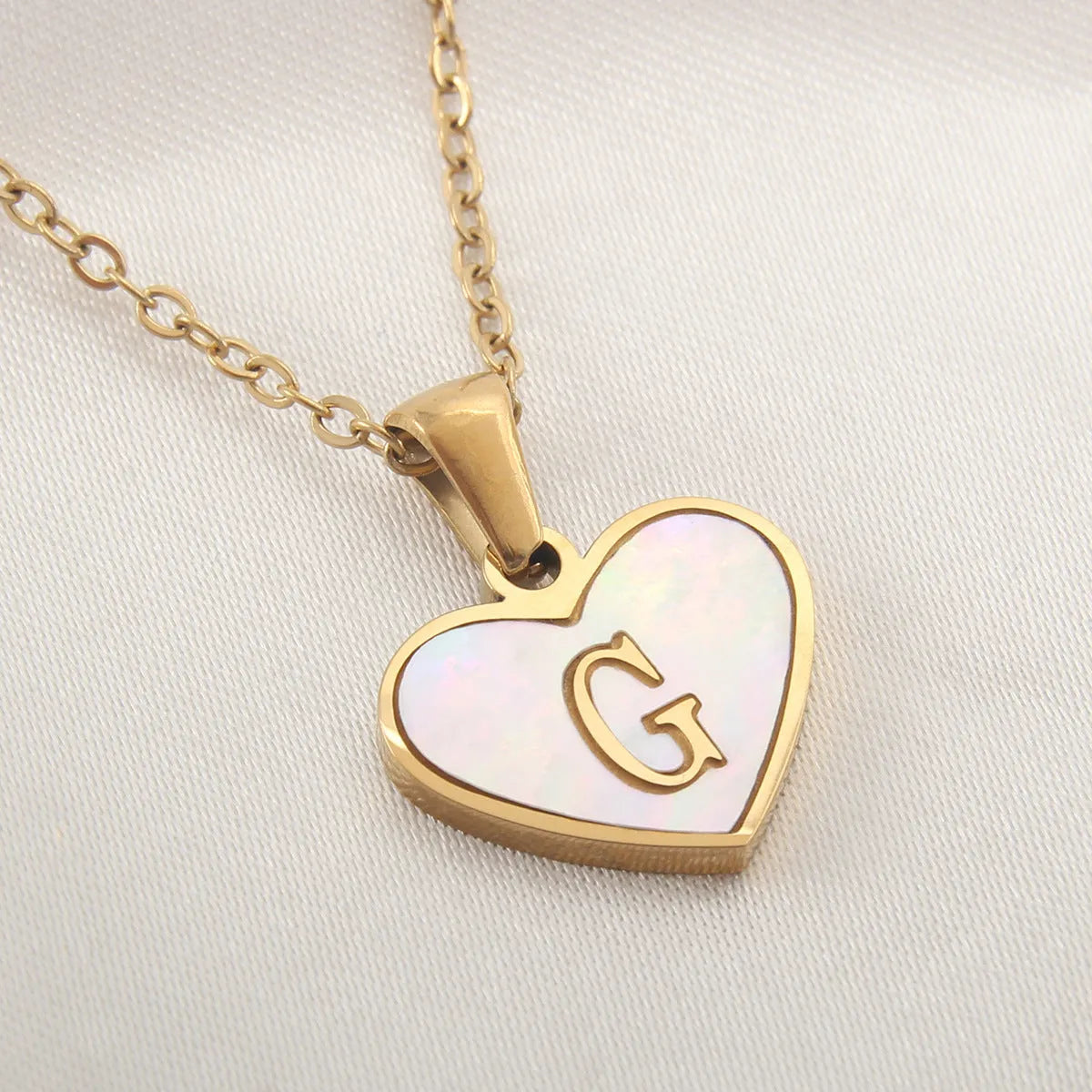 Gold plated heart-shaped white shell pendant personalised initial necklace on a stainless steel chain.