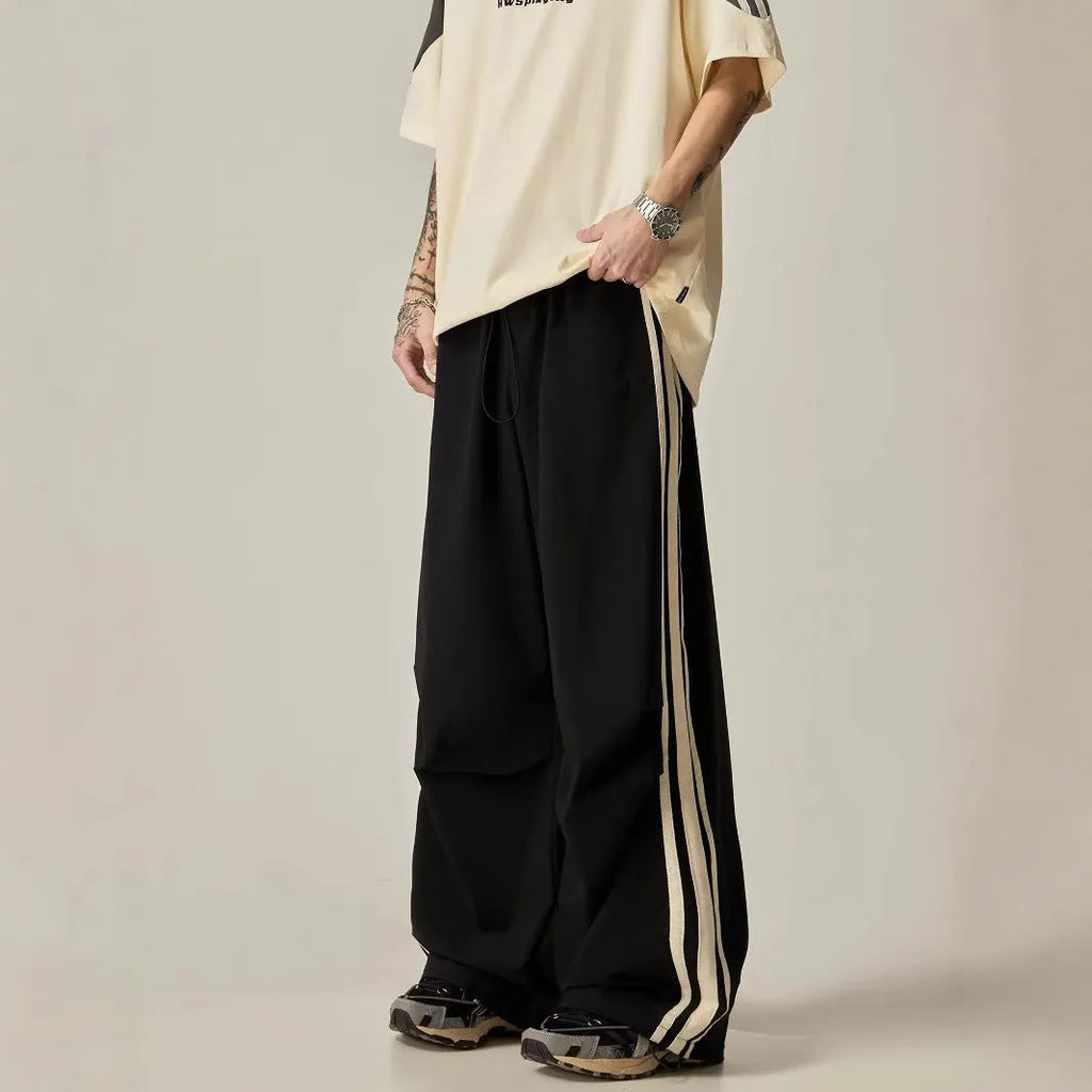 A man wearing black high-waisted wide-leg straight-cut casual climbing trousers.
