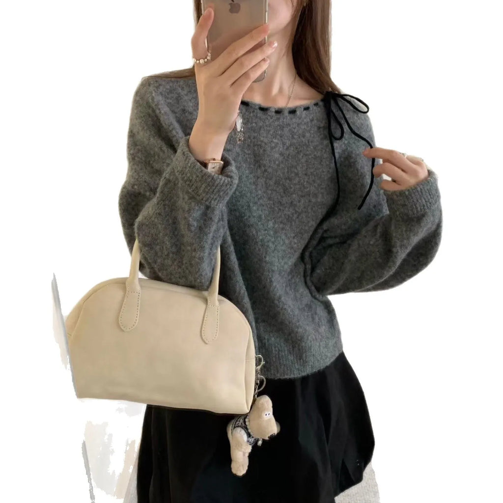 A grey women's loose-fitting long-sleeve knitwear pullover top on a hanger.