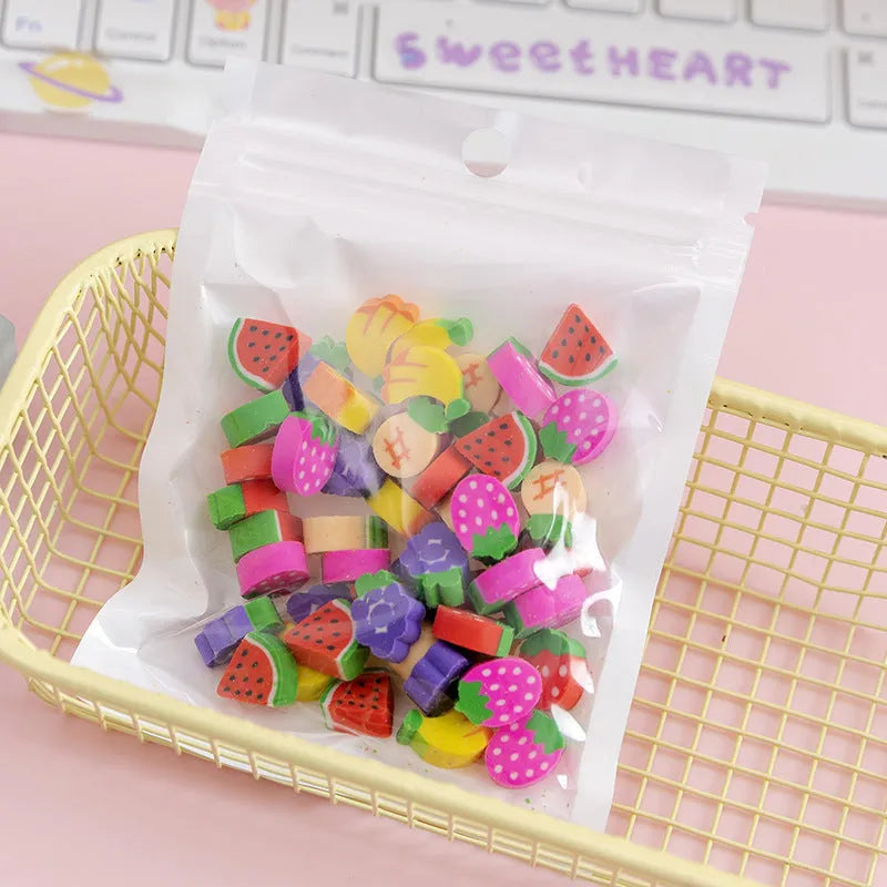 50 colourful cartoon mini erasers in shapes of fruits, animals, and cakes, displayed next to a pearlescent film bag.