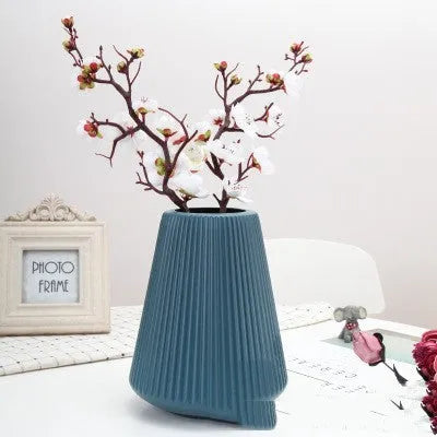 Melamine plastic flower vase in blue colour on desktop with white flowers
