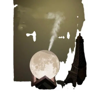 White spherical lunar humidifier night light with USB charging cable on a wooden surface.