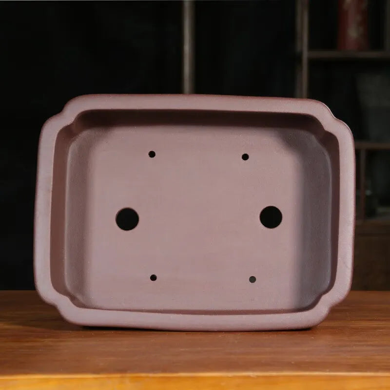 Antique-style rectangular purple sand planter with cut corners on a floor.