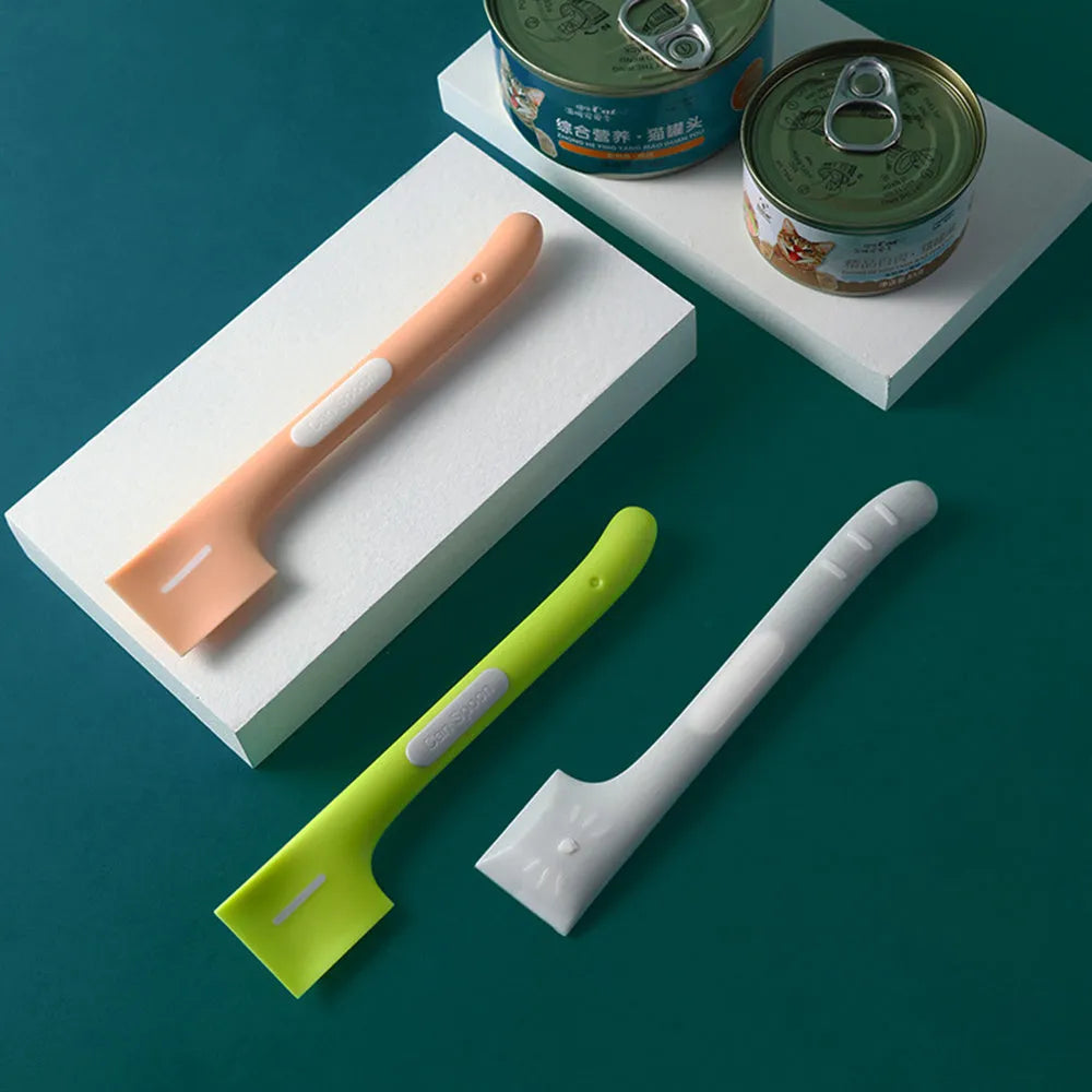 Green long-handle pet feeding spoon for canned cat and dog food on a white background.