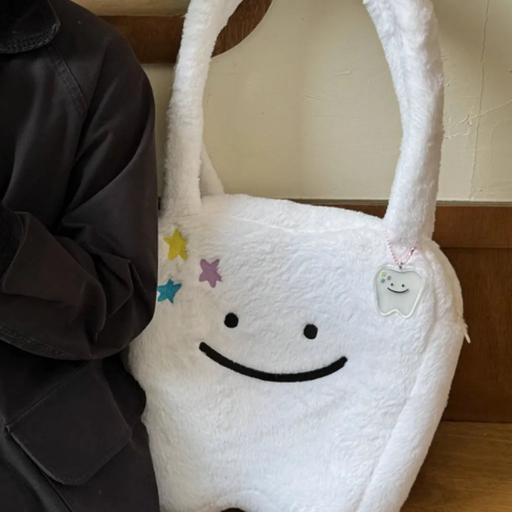 White plush large tooth shoulder tote bag with crossbody strap and zipper.