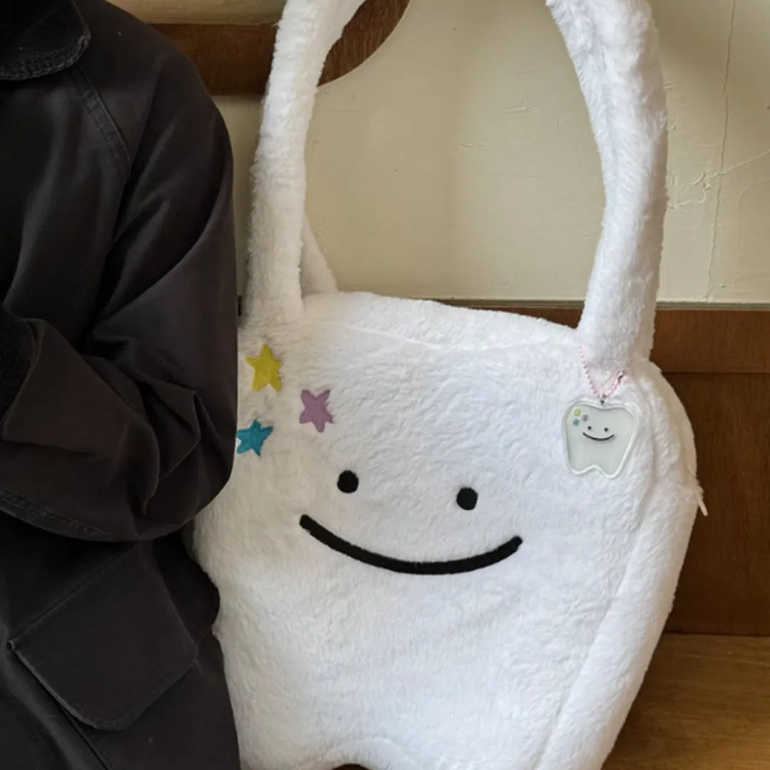 White plush large tooth shoulder tote bag with crossbody strap and zipper.