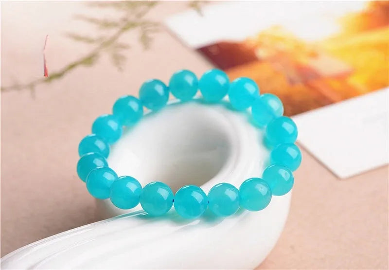 Polished natural Amazonite scattered beads in blue-green ice colours on a white background, showing different sizes from 6mm to 13mm.