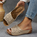 Women's black beach slipper with flower cutouts, a fish mouth toe, and a low wedge heel on a rubber sole.