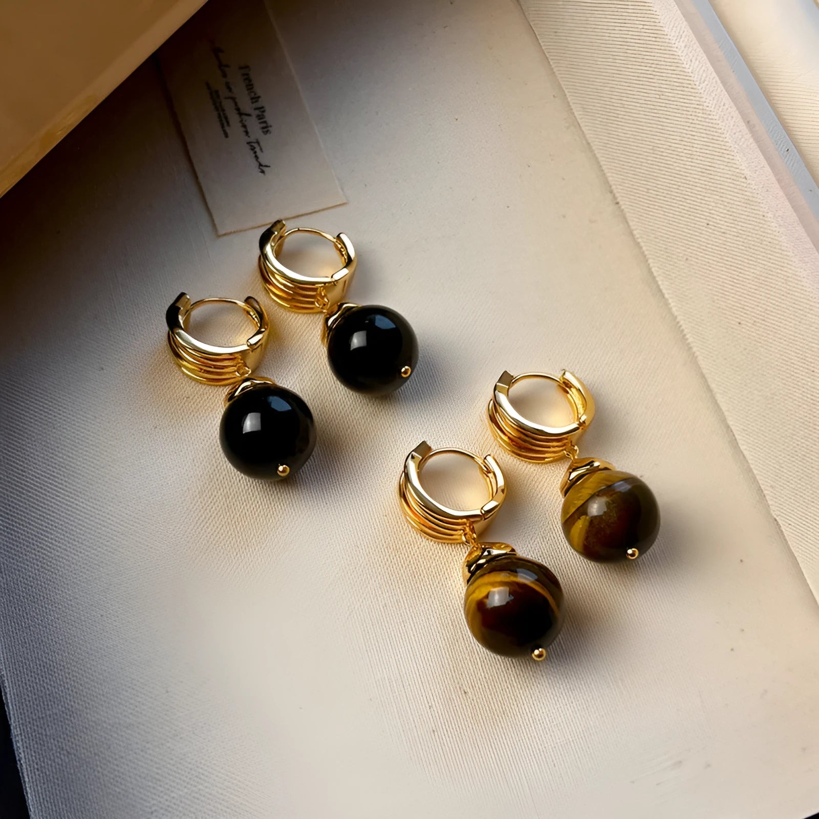 Gold-plated geometric earrings made from brown and black Tigereye stone in a French retro style.