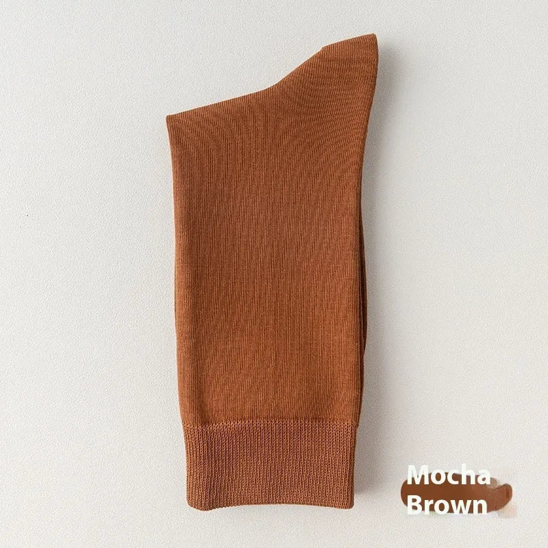 Mid-calf men's socks in solid colours made from combed cotton, shown in a stack.
