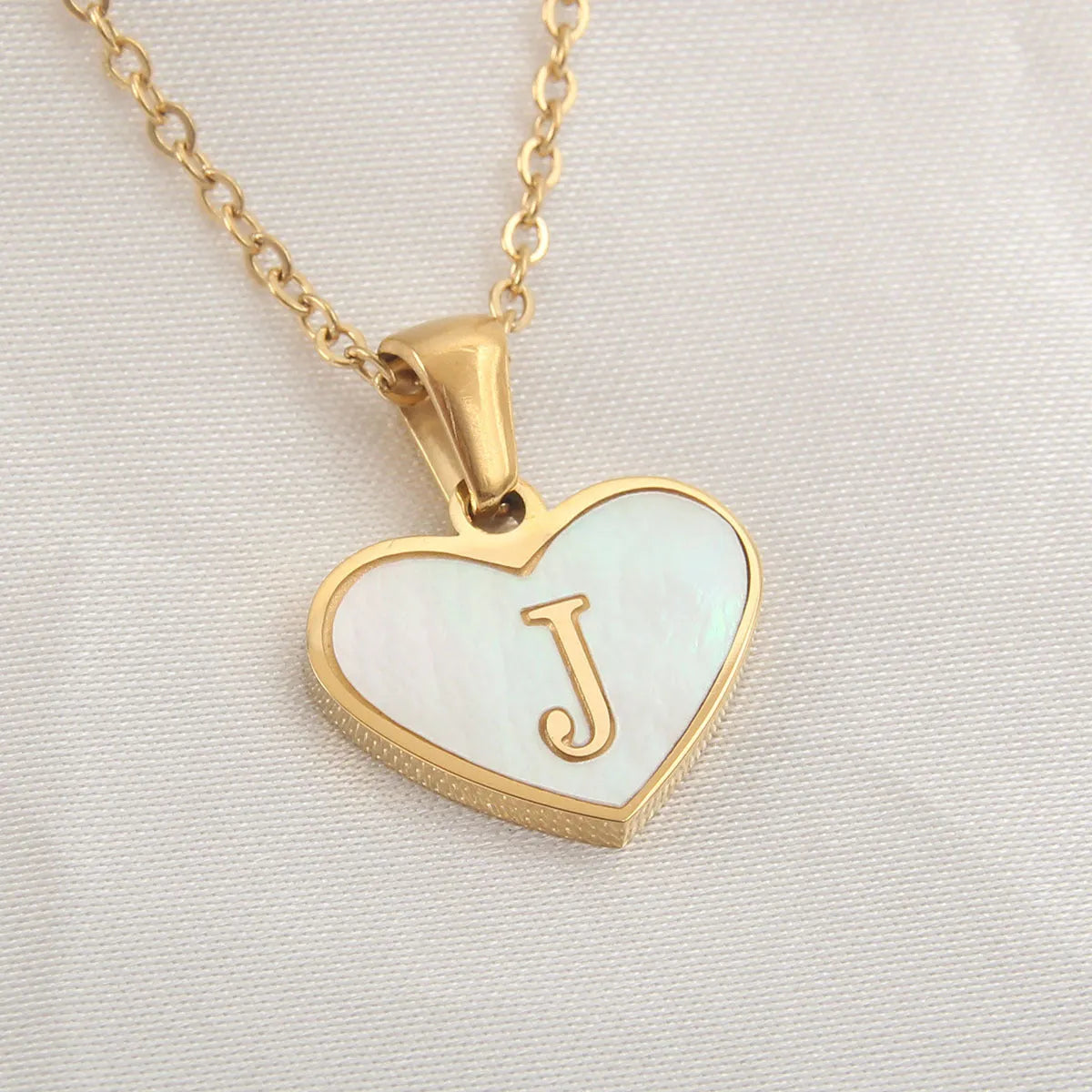 Gold plated heart-shaped white shell pendant personalised initial necklace on a stainless steel chain.