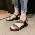 Women's silver flat sandals with elastic band and rhinestone sequin detail on a round toe.