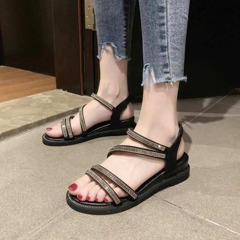 Women's silver flat sandals with elastic band and rhinestone sequin detail on a round toe.
