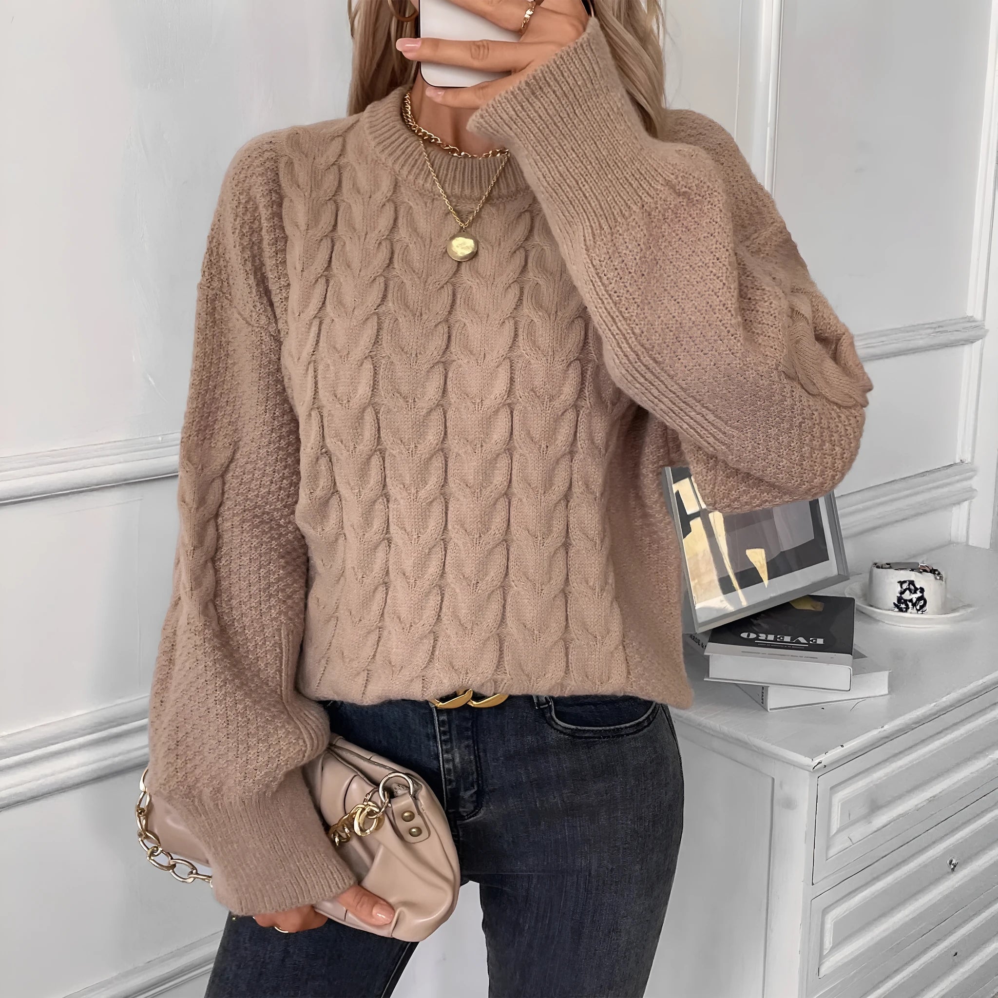Women's loose beige round neck sweater showing twisted texture detail on the front.