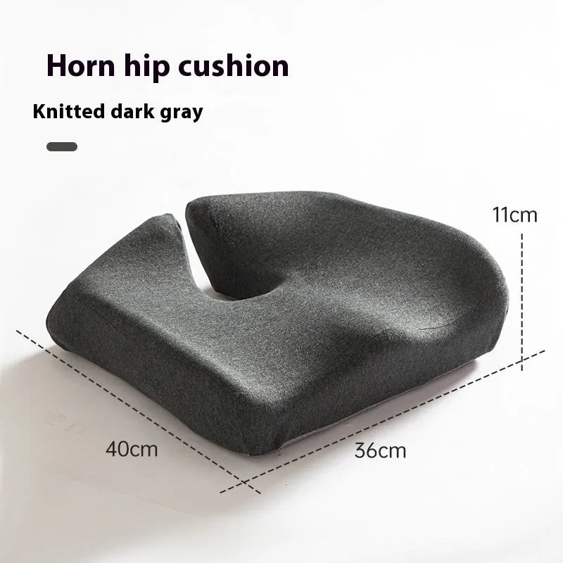 Dark grey memory foam office chair cushion with contoured shape for lower back support on a desk chair.