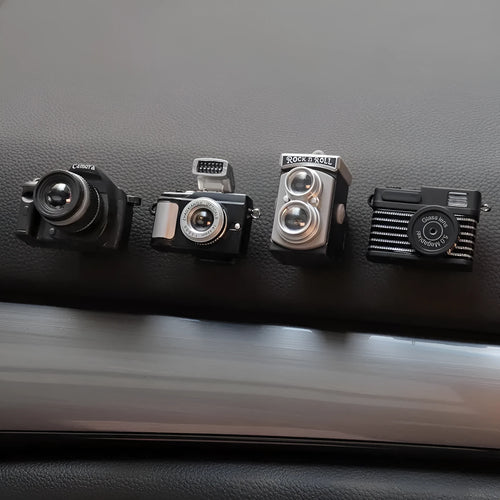 Set of four retro camera dot design plastic adhesive hooks for car dashboard organisation.