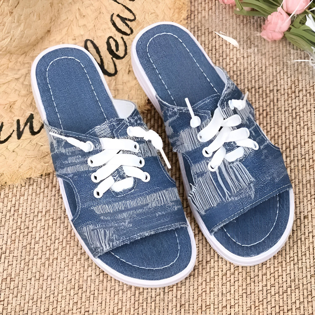 Blue women's flat Roman-style canvas slippers with cloth upper and rubber sole.